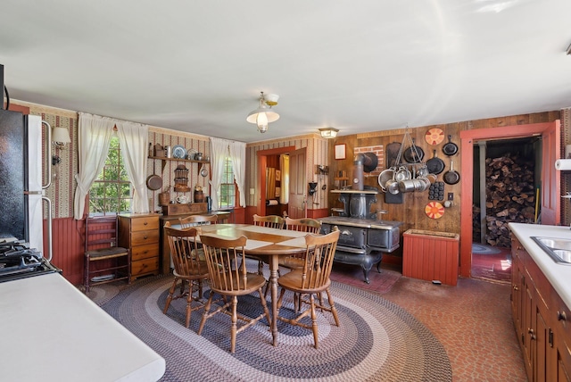 19 Bearce Rd, Winthrop, ME 04364 - dining room featuring radiator, a wood stove, wooden walls, and carpet flooring