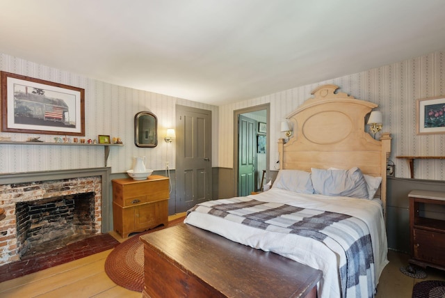 19 Bearce Rd, Winthrop, ME 04364 - bedroom featuring wallpapered walls, wood finished floors, and a fireplace