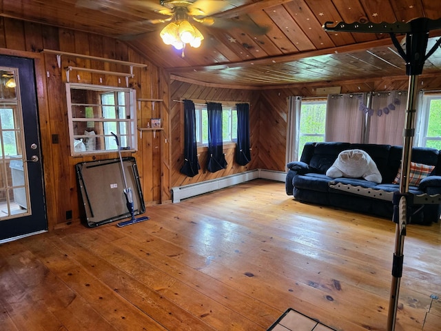 1330 Pushaw Rd, Glenburn, ME 04401 - living room featuring ceiling fan, a baseboard radiator, wood walls, hardwood / wood-style flooring, and lofted ceiling