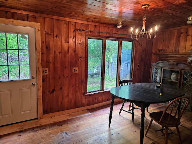 1330 Pushaw Rd, Glenburn, ME 04401 - dining room with wood walls, a chandelier, wood ceiling, and hardwood / wood-style floors