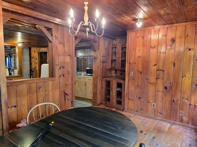 1330 Pushaw Rd, Glenburn, ME 04401 - dining space with wooden walls, wooden ceiling, a chandelier, and hardwood / wood-style flooring
