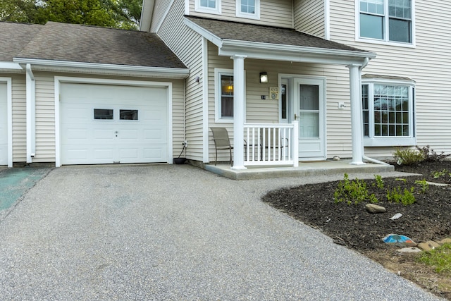 14 Chickadee Cir Unit 14, Brunswick, ME 04011 - doorway to property featuring covered porch, an attached garage, asphalt driveway, and a shingled roof