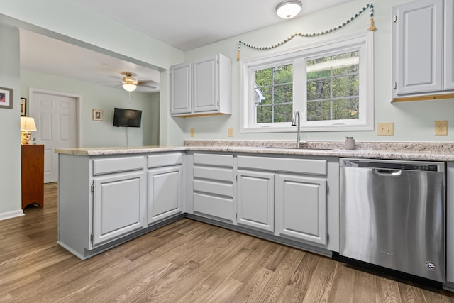 14 Chickadee Cir Unit 14, Brunswick, ME 04011 - kitchen with stainless steel dishwasher, a sink, light countertops, light wood-type flooring, and a peninsula
