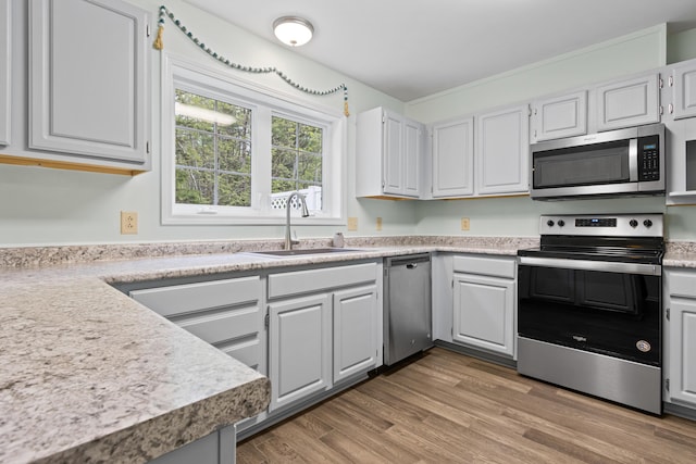 14 Chickadee Cir Unit 14, Brunswick, ME 04011 - kitchen featuring stainless steel appliances, a sink, light countertops, light wood-style floors, and white cabinetry