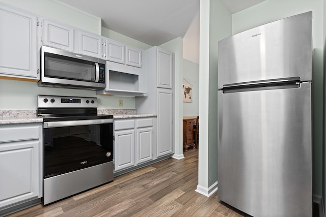 14 Chickadee Cir Unit 14, Brunswick, ME 04011 - kitchen with appliances with stainless steel finishes, light wood-style flooring, baseboards, and white cabinetry