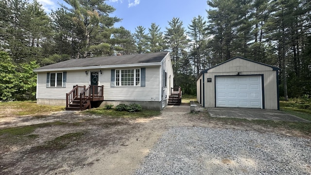 60 Twig Cir, Harrison, ME 04040 - view of front of house with gravel driveway, an outbuilding, a detached garage, and view of wooded area