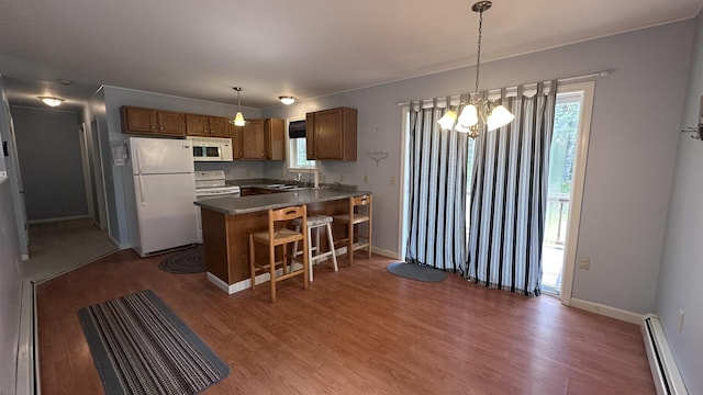 60 Twig Cir, Harrison, ME 04040 - kitchen featuring white appliances, a baseboard radiator, a sink, a peninsula, and a chandelier