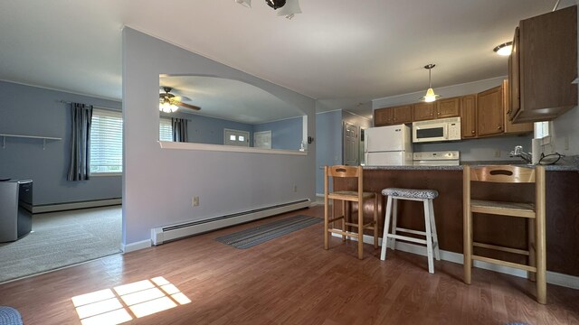 60 Twig Cir, Harrison, ME 04040 - kitchen with white appliances, a baseboard radiator, a peninsula, and wood finished floors