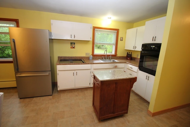 kitchen with black appliances, a sink, a baseboard radiator, and white cabinets