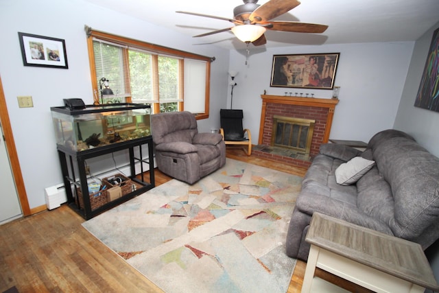 living room featuring wood finished floors, a ceiling fan, and a fireplace