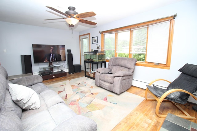 living area featuring wood finished floors, a ceiling fan, and baseboard heating
