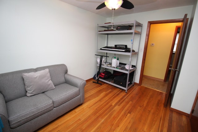 sitting room with a ceiling fan, wood finished floors, and baseboards