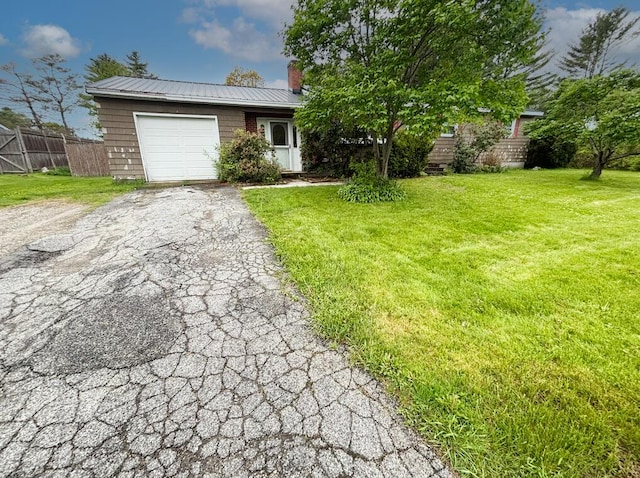 view of front of home with driveway, an attached garage, a chimney, and metal roof