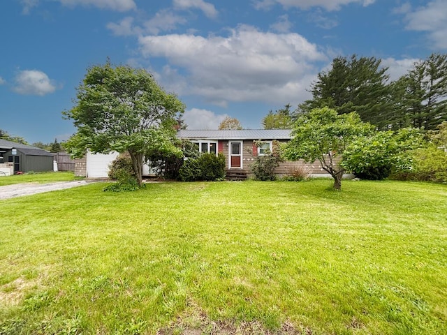 view of front of home with dirt driveway, a front lawn, metal roof, and a garage
