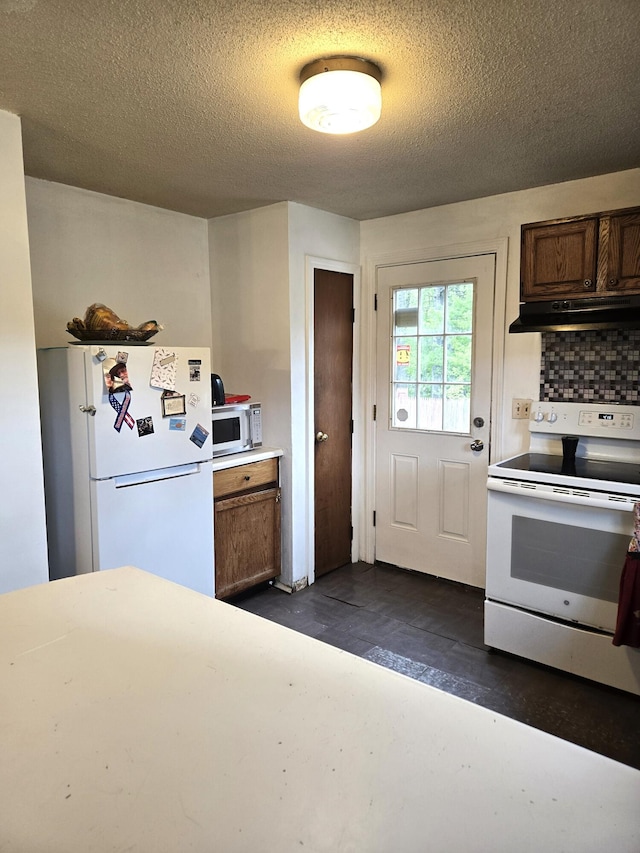 25 Mill Ln, Naples, ME 04055 - kitchen with white appliances, under cabinet range hood, light countertops, brown cabinetry, and a textured ceiling