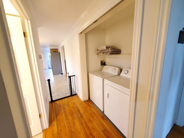 259-265 Bowden Point Rd, Prospect, ME 04981 - laundry area featuring washing machine and dryer, light wood-type flooring, and crown molding