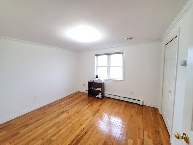 259-265 Bowden Point Rd, Prospect, ME 04981 - unfurnished bedroom featuring a baseboard heating unit, light wood-type flooring, ornamental molding, and baseboards