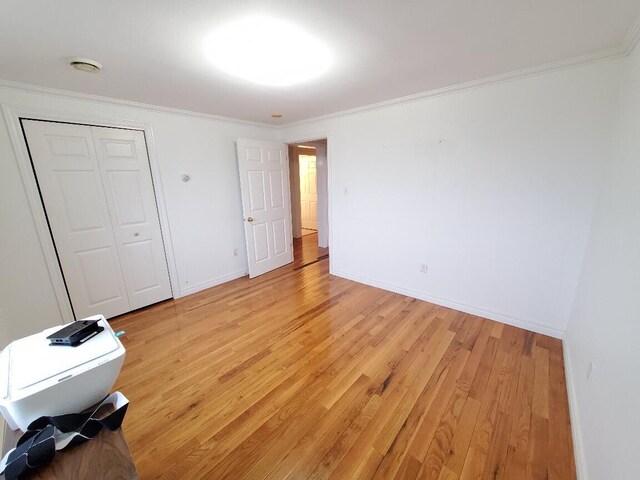 259-265 Bowden Point Rd, Prospect, ME 04981 - unfurnished bedroom with light wood-style flooring, ornamental molding, baseboards, and a closet