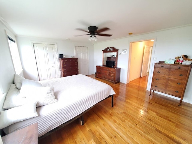 259-265 Bowden Point Rd, Prospect, ME 04981 - bedroom featuring two closets, light wood finished floors, crown molding, and ceiling fan