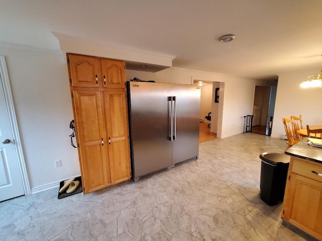 259-265 Bowden Point Rd, Prospect, ME 04981 - kitchen featuring high quality fridge, light stone finish floors, a chandelier, ornamental molding, and brown cabinetry