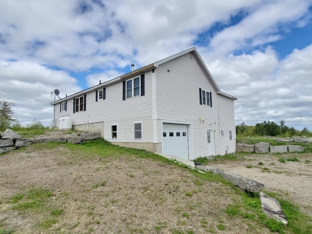 259-265 Bowden Point Rd, Prospect, ME 04981 - rear view of house featuring a garage and driveway