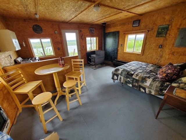 259-265 Bowden Point Rd, Prospect, ME 04981 - bedroom with a wood stove, finished concrete flooring, and multiple windows