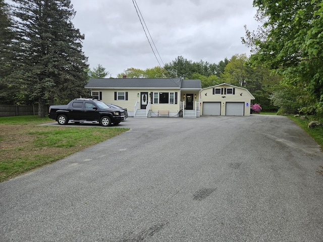 single story home featuring entry steps, driveway, an attached garage, and metal roof