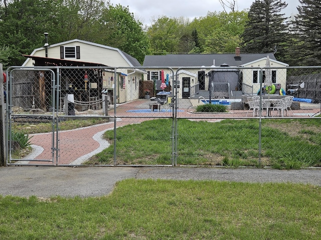 rear view of house featuring a gate, a patio, and a gambrel roof