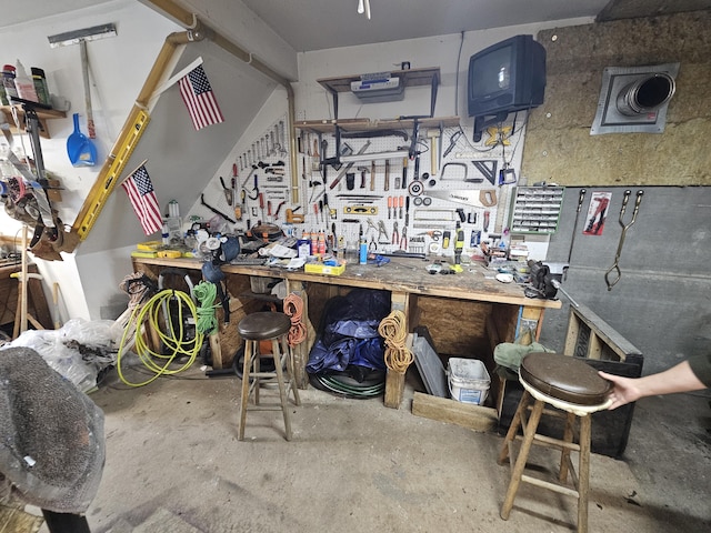miscellaneous room featuring a workshop area and concrete flooring