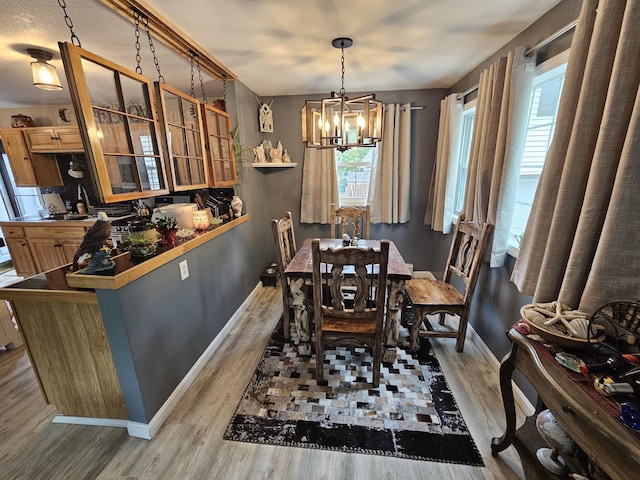 dining room with wood finished floors, a chandelier, and baseboards