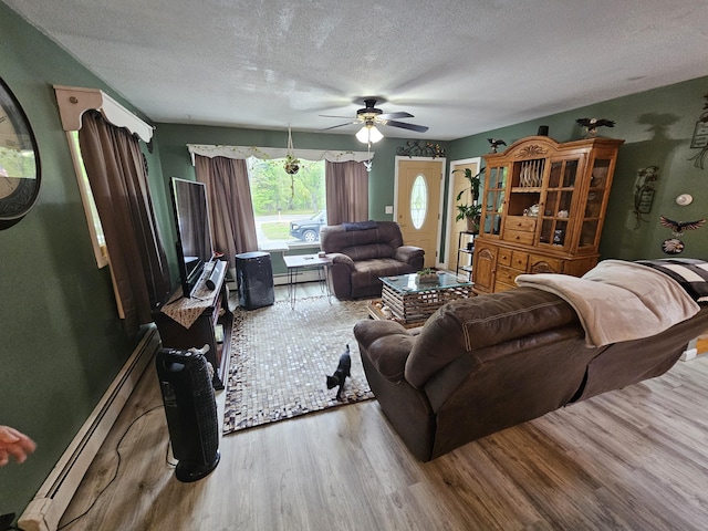 living room featuring a baseboard heating unit, wood finished floors, a textured ceiling, and a ceiling fan