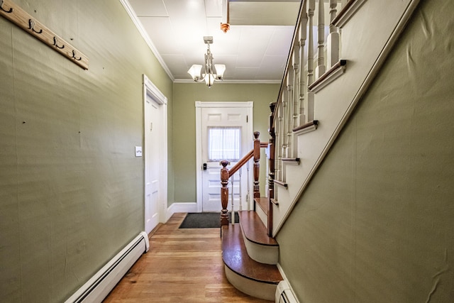 45 High St, Biddeford, ME 04005 - entryway with light wood-style flooring, crown molding, a baseboard heating unit, a chandelier, and stairs
