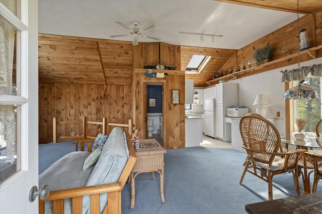 197 Ash Point Rd, Harpswell, ME 04079 - dining room with lofted ceiling, light colored carpet, wooden walls, ceiling fan, and rail lighting