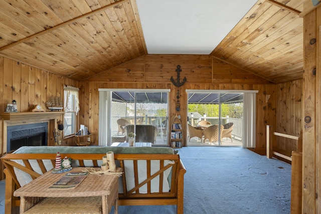 197 Ash Point Rd, Harpswell, ME 04079 - living room with lofted ceiling, wood walls, a fireplace, healthy amount of natural light, and carpet