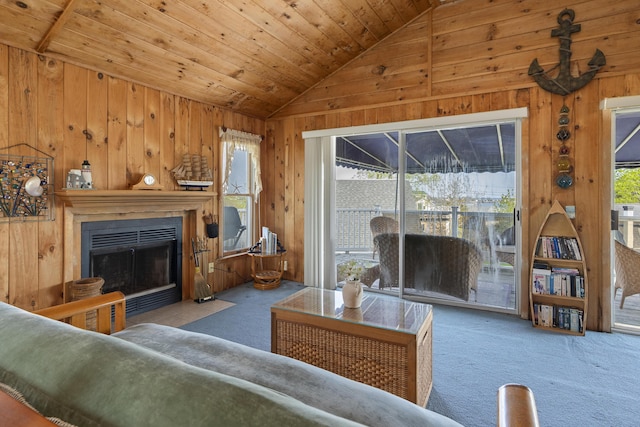 197 Ash Point Rd, Harpswell, ME 04079 - living area with vaulted ceiling, carpet floors, wooden walls, wood ceiling, and a fireplace with flush hearth