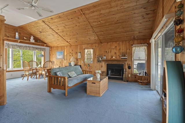 197 Ash Point Rd, Harpswell, ME 04079 - carpeted living area featuring lofted ceiling, wood walls, a ceiling fan, a fireplace with flush hearth, and wood ceiling