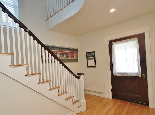 228 French St, Bangor, ME 04401 - entrance foyer featuring radiator, healthy amount of natural light, light wood-type flooring, stairway, and a wainscoted wall
