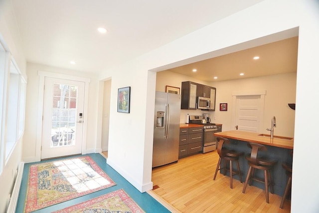 228 French St, Bangor, ME 04401 - kitchen featuring stainless steel appliances, a sink, a breakfast bar, recessed lighting, and baseboards
