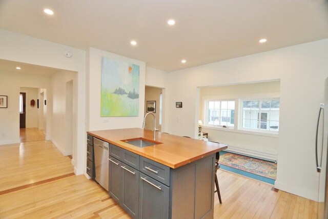 228 French St, Bangor, ME 04401 - kitchen featuring a sink, a baseboard radiator, dishwasher, wooden counters, and light wood-style flooring