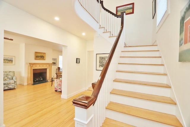 228 French St, Bangor, ME 04401 - stairway with wood finished floors, recessed lighting, a fireplace, a towering ceiling, and baseboards