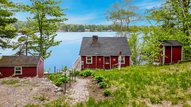 72 Logan Cir, Waterboro, ME 04030 - rear view of property featuring a chimney, a water view, and roof with shingles