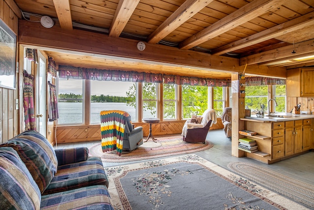 72 Logan Cir, Waterboro, ME 04030 - living room featuring wooden walls, wood ceiling with exposed beams, concrete flooring, and a water view