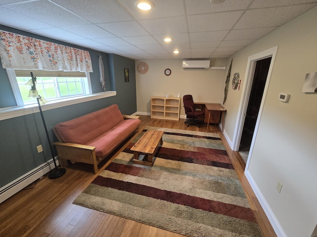 101 Streamside Ln Unit 21, Bangor, ME 04401 - living area featuring a wall mounted AC, a drop ceiling, wood finished floors, baseboard heating, and baseboards