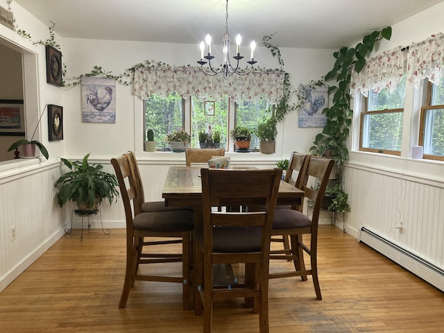 34 Highview Ave, Hancock, ME 04640 - dining area featuring baseboard heating, a chandelier, light wood-style flooring, and wainscoting