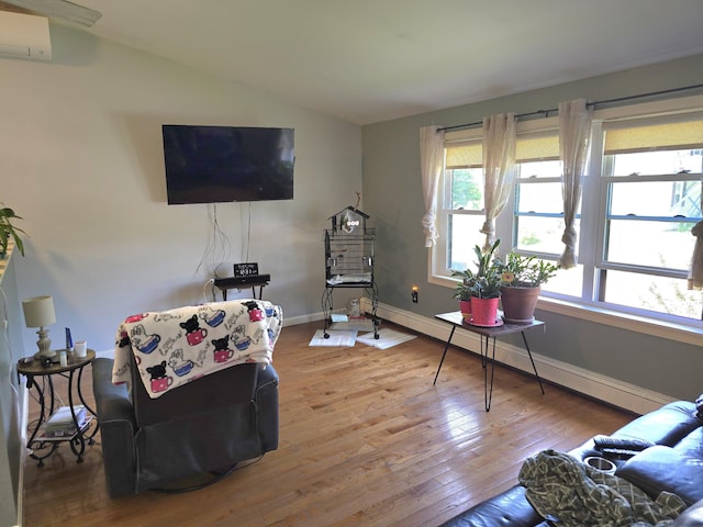 5 Roland Ave, Lewiston, ME 04240 - living room featuring hardwood / wood-style flooring, a wall mounted air conditioner, vaulted ceiling, baseboards, and a baseboard radiator