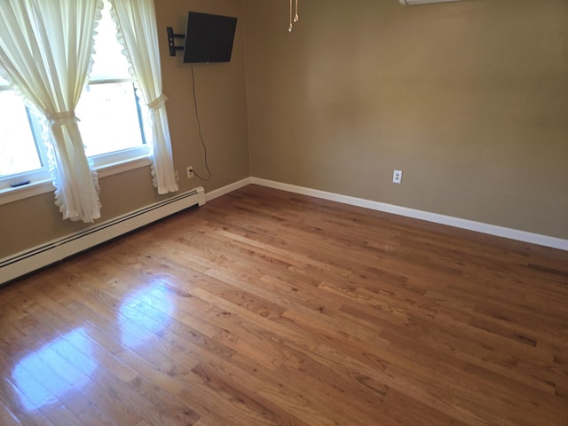 5 Roland Ave, Lewiston, ME 04240 - empty room featuring wood finished floors, a baseboard radiator, and baseboards