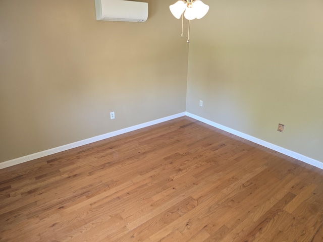 5 Roland Ave, Lewiston, ME 04240 - empty room with a wall unit AC, a ceiling fan, baseboards, and wood finished floors