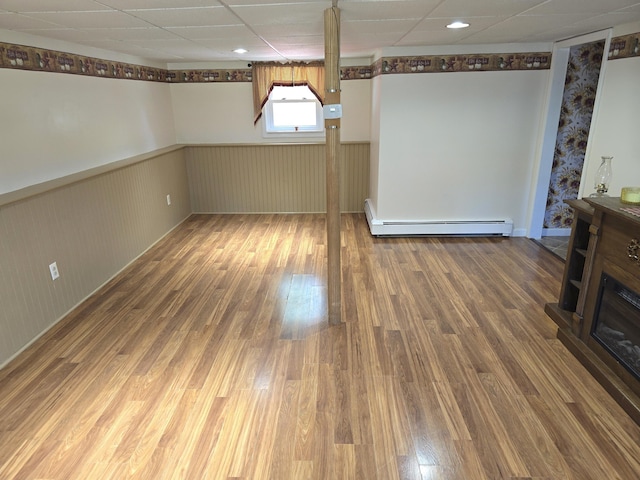 5 Roland Ave, Lewiston, ME 04240 - unfurnished dining area featuring baseboard heating, a wainscoted wall, wood finished floors, and a fireplace