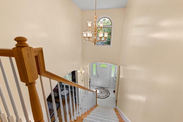 31 Rebecca Rd, Ogunquit, ME 03907 - stairs with a chandelier, baseboards, wood finished floors, and a towering ceiling