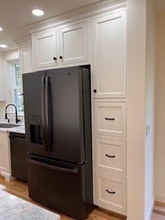 12 Windsor Rd, Ellsworth, ME 04605 - kitchen with black fridge, a sink, white cabinets, light countertops, and recessed lighting
